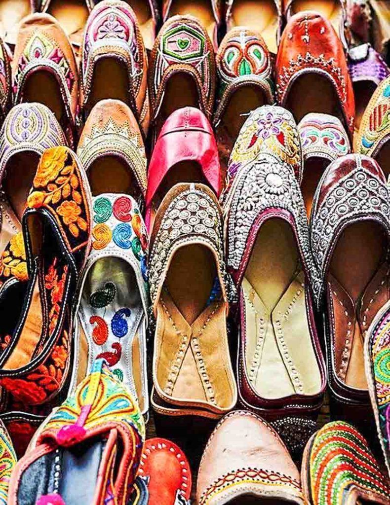 Bombay-bazares-que-ver-en-Bombay Zapatos tradicionales indios bordados y llenos de color en un mercado típico que ver en Bombay.