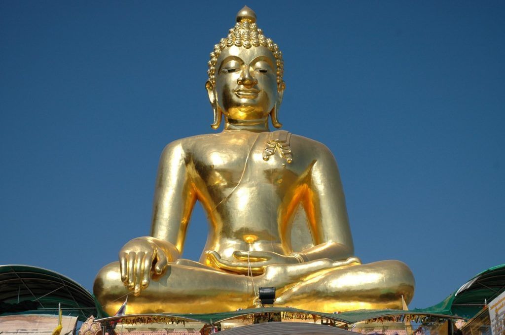 Gran estatua dorada de Buda en Tailandia, un lugar donde es importante respetar la vestimenta en los templos de Tailandia.