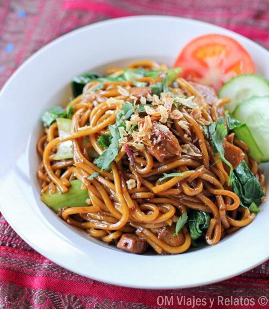 Plato de mie goreng con verduras y especias locales, una experiencia gastronómica típica cerca de las cascadas de Lombok.