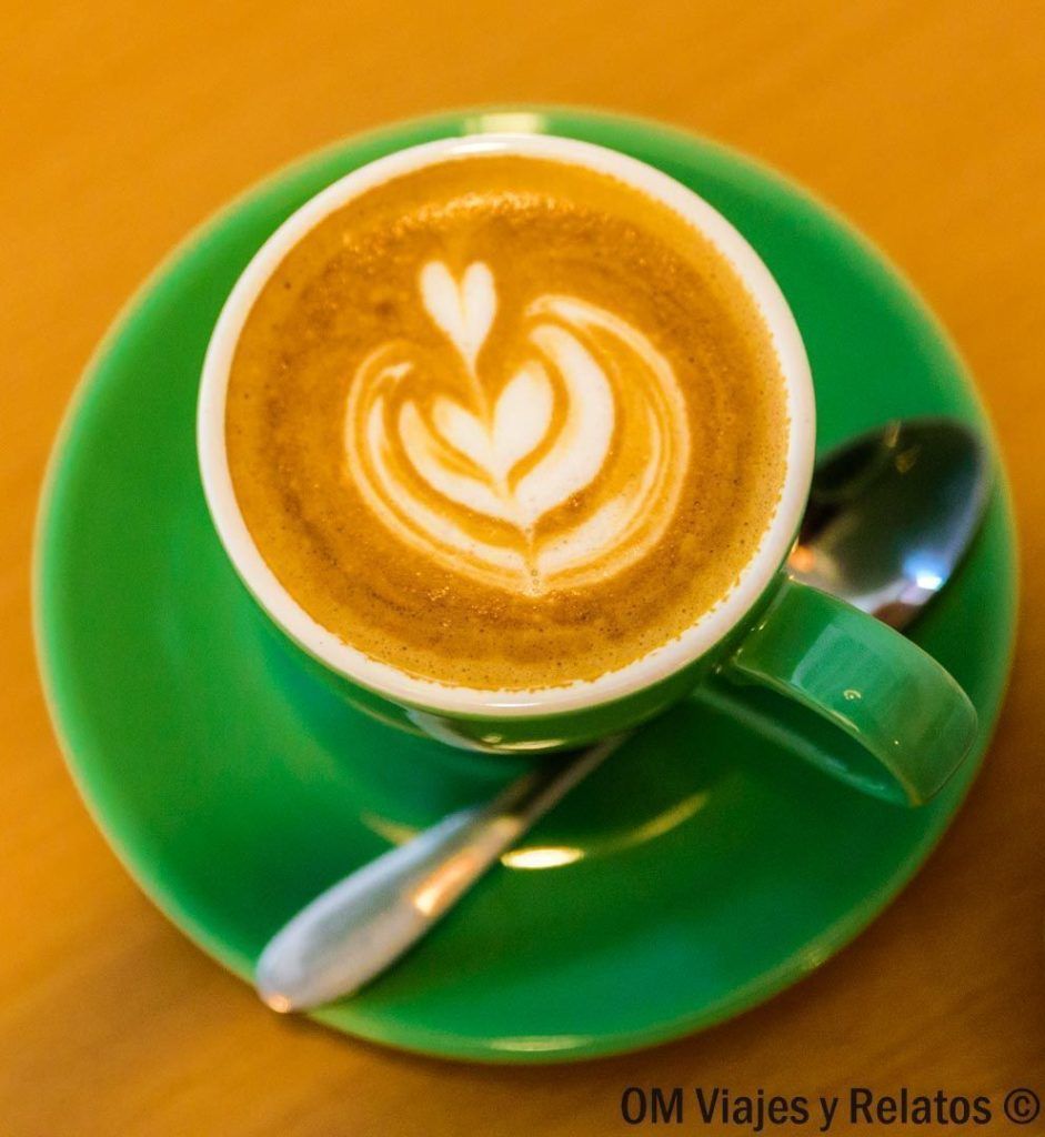 café-Kopi-Singapur Café kopi con latte art servido en taza verde, una pausa gastronómica típica que disfrutar mientras descubres que ver en Singapur en 2 dias.