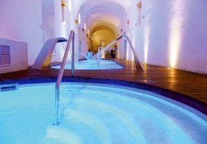 Spa interior del hotel Monasterio de Piedra con piscina de hidromasaje en un espacio abovedado, una opción de relax para completar tu visita a qué ver en el Monasterio de Piedra.