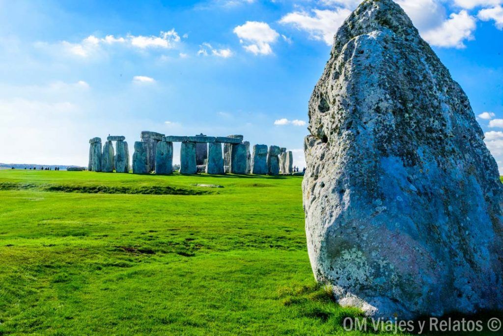 Primer plano de una piedra de Stonehenge con el círculo megalítico al fondo, un lugar histórico imprescindible que ver cerca de Londres.