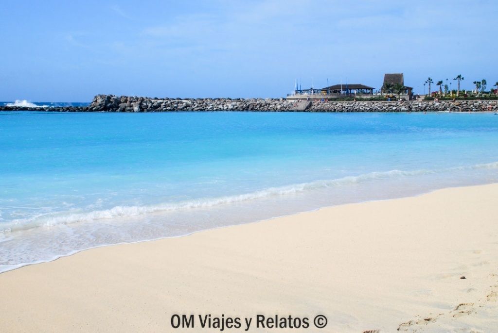 Playa de Amadores en Gran Canaria con arena blanca y aguas turquesas protegidas, una de las mejores playas de las Islas Canarias para disfrutar del mar en familia.
