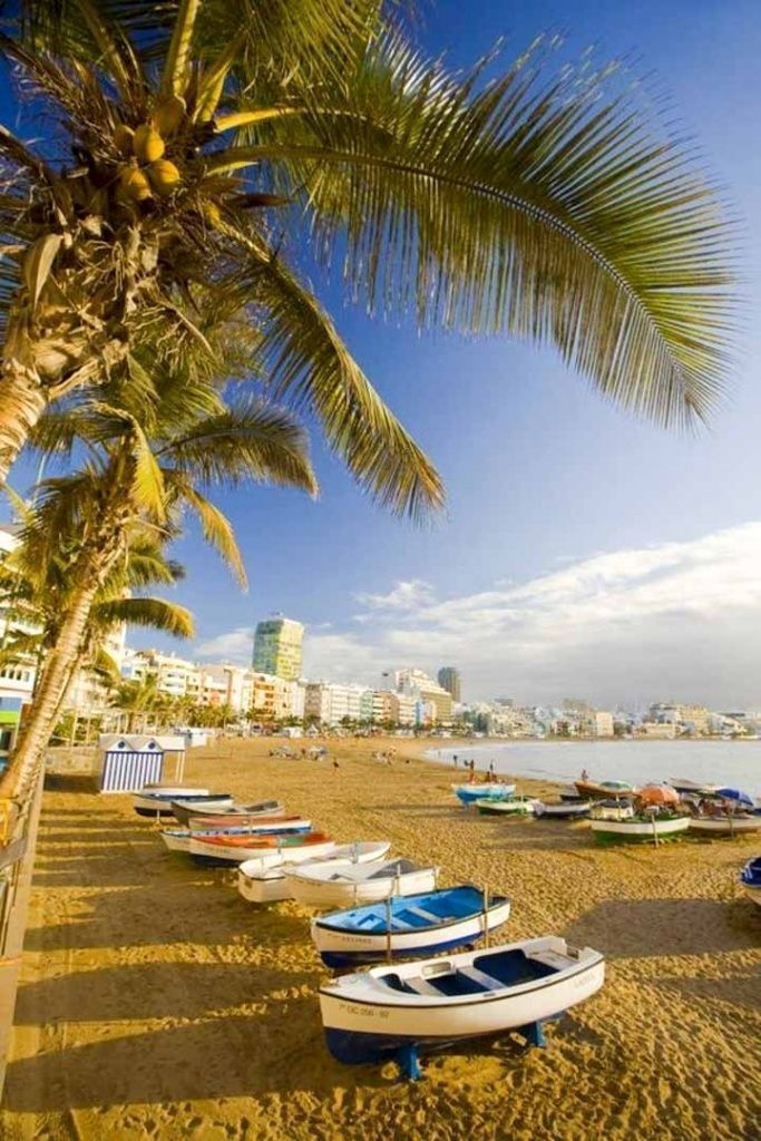 Vista de la Playa de Las Canteras con pequeñas barcas varadas en la arena y ambiente costero urbano, una imagen perfecta para descubrir que ver en Gran Canaria en 7 días.