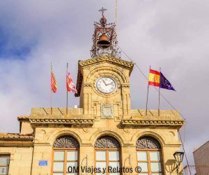 Ayuntamiento de un pueblo de los Arribes del Duero con reloj y banderas, una parada cultural para completar un paseo en barco por los Arribes del Duero.