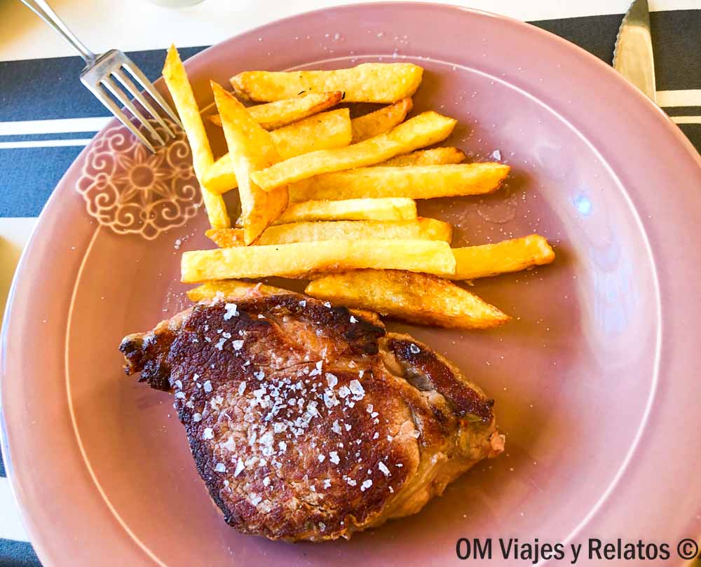 Plato de carne a la plancha con patatas fritas, plan gastronómico que ver en Buitrago del Lozoya en un día.
