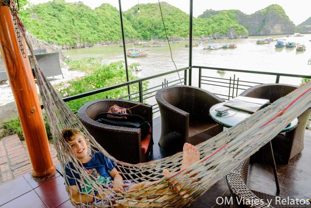 Que ver en Vietnam en 15 días: Raúl descansando en una hamaca en una terraza con vistas a la bahía de Halong y sus barcos entre islotes kársticos.