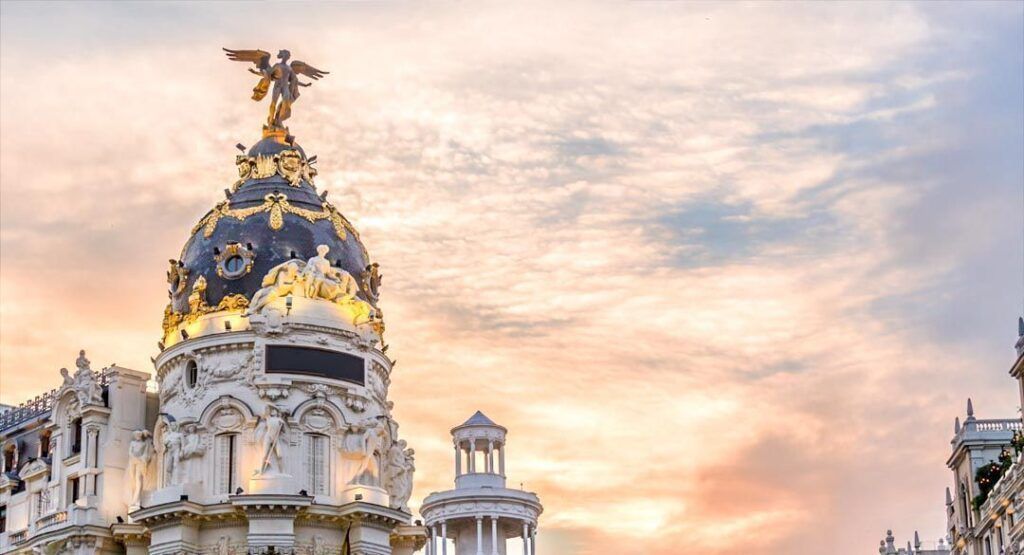 Cúpula del edificio Metrópolis al atardecer en la Gran Vía, una postal icónica que ver en Madrid en 3 días.