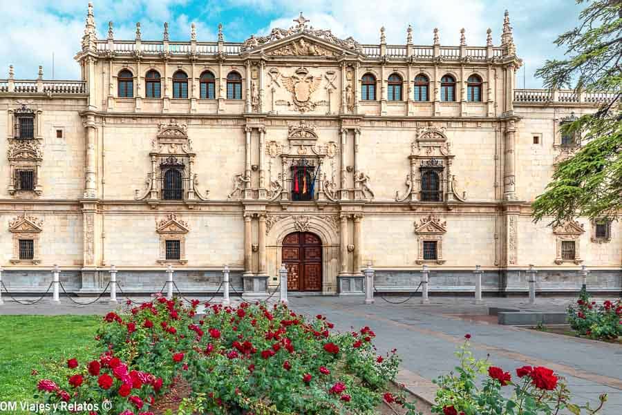 Fachada de la Universidad de Alcalá de Henares con rosales, uno de los sitios para visitar cerca de Madrid.