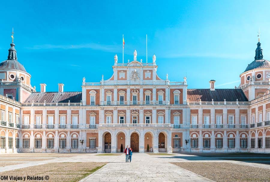 JC y Raúl delante del Palacio Real de Aranjuez, uno de los sitios para visitar cerca de Madrid en una escapada histórica.