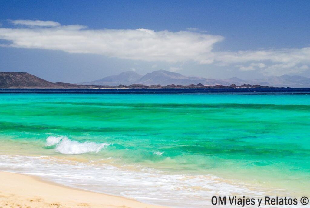 Playa de aguas turquesas y arena blanca en Fuerteventura, una de las mejores playas de las Islas Canarias por sus paisajes paradisíacos y su entorno natural.