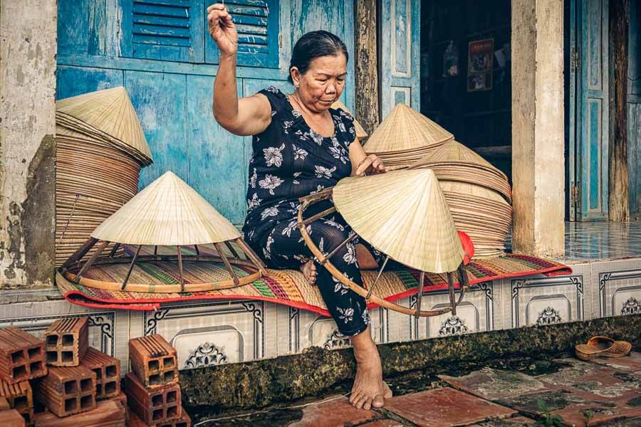 Artesana vietnamita haciendo sombreros cónicos en una guía sobre que ver en Hanoi en dos días.