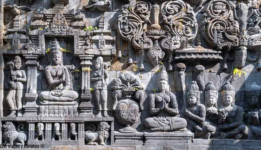 Relieve de piedra con figuras budistas y motivos ornamentales inspirado en el arte de los templos de Java Central, un valioso legado cultural que ver en Yogyakarta.