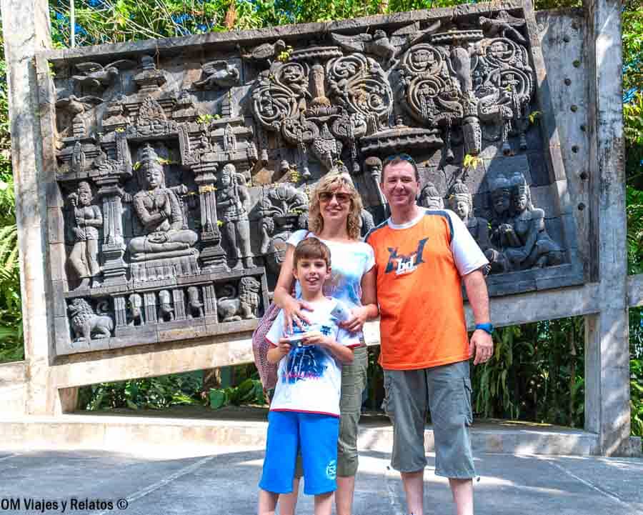 Foto familiar de OM Viajes y Relatos visitando un relieve de piedra con escenas budistas e hinduistas cerca de Yogyakarta, una muestra del rico patrimonio cultural e histórico que descubrir entre los principales lugares que ver en Yogyakarta y alrededores.