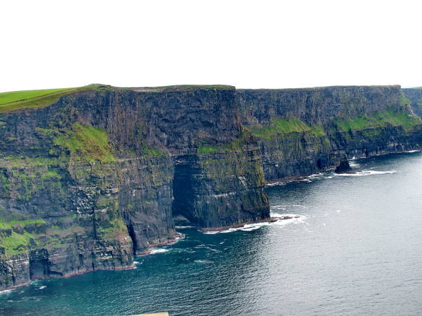 Vista panorámica al visitar los acantilados de Moher, con enormes paredes de roca sobre el océano Atlántico en la costa de Irlanda.