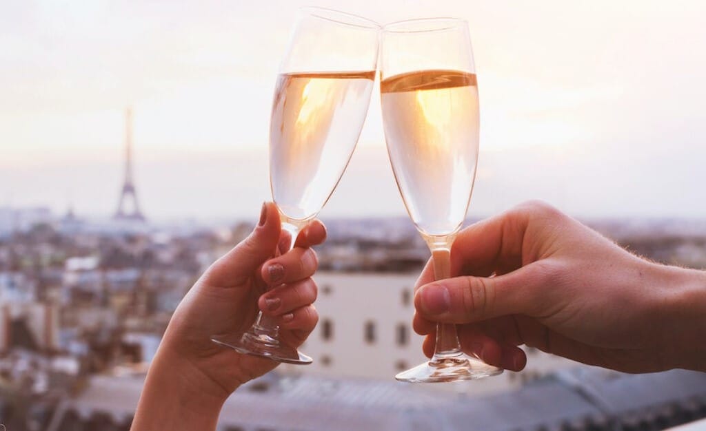 Brindis con champán al atardecer con la Torre Eiffel al fondo, una de las cosas románticas que hacer en París.