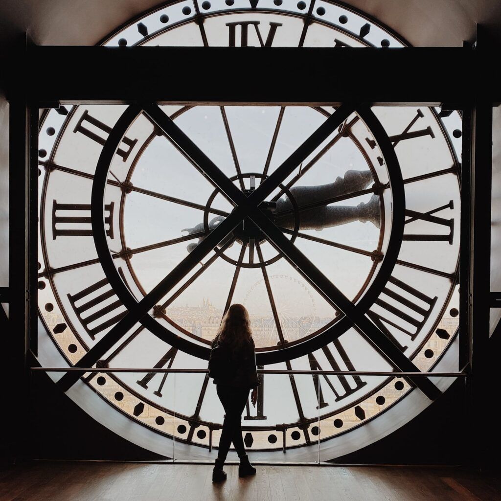 Foto mía mirando París a través del reloj gigante del Museo de Orsay en Paris en 3 días.