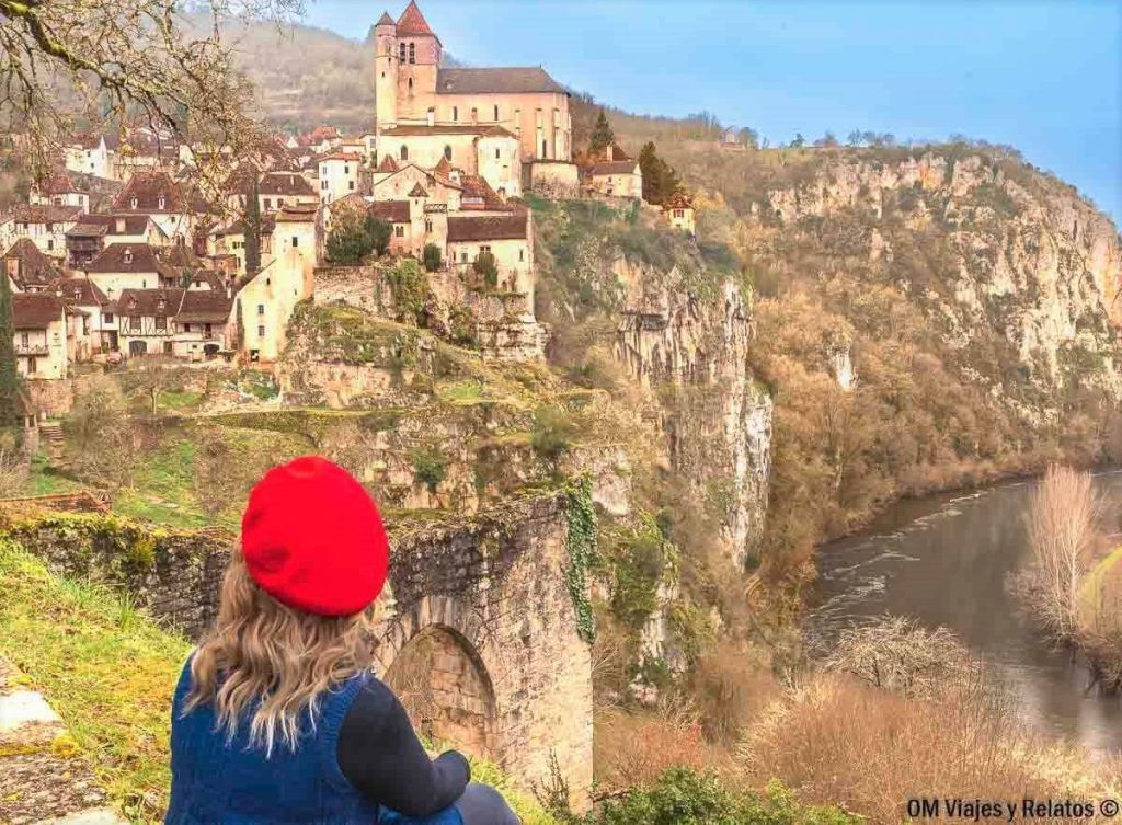 Foto mía contemplando Saint-Cirq-Lapopie sobre el acantilado junto al río, una parada imprescindible en una ruta por los pueblos mas bonitos del sur de Francia.