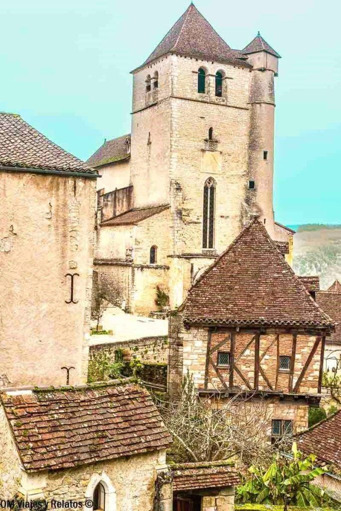 Iglesia y casas medievales de Saint-Cirq-Lapopie con tejados de teja y entramado de madera, una parada imprescindible en una ruta por los pueblos mas bonitos del sur de Francia.