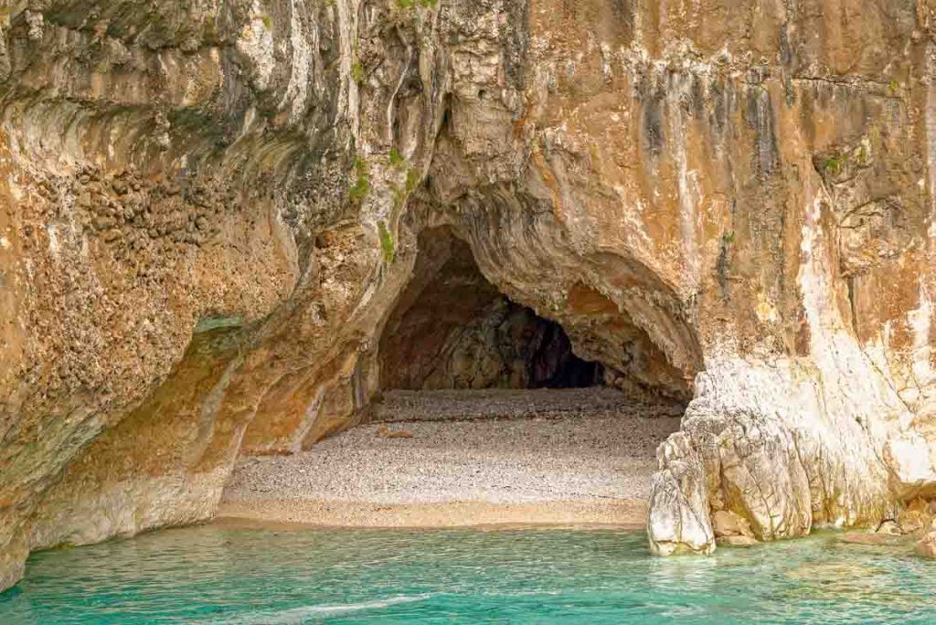 Cala Mudaloru con cueva natural y aguas turquesas durante una excursion en barco por el golfo de Orosei.