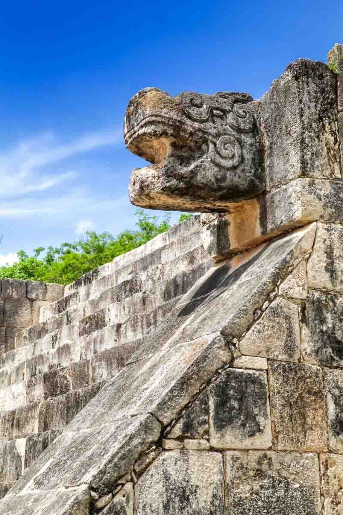 Cabeza de serpiente tallada en piedra en Chichén Itzá, un detalle arqueológico imprescindible que ver en Chichen Itzá.