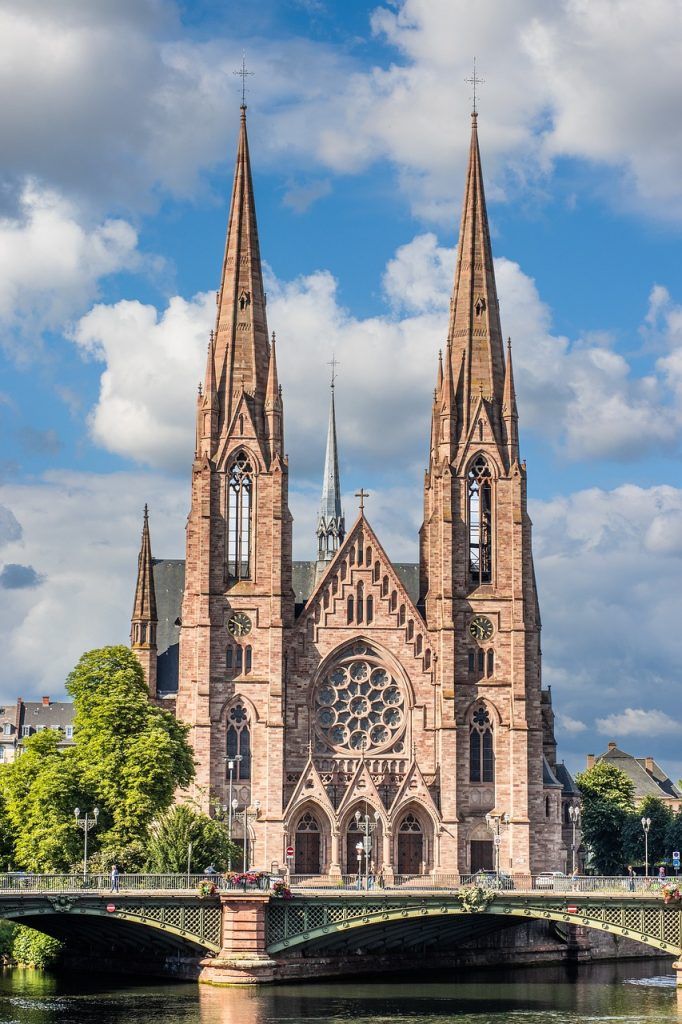 Iglesia de San Pablo con sus dos torres junto al río, un imprescindible de que ver en Estrasburgo en un día.
