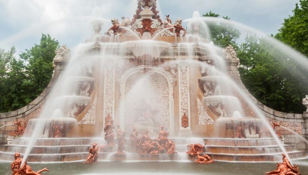 Fuente de los Baños de Diana en las Fuentes de la Granja de San Ildefonso con cascadas y esculturas rodeadas de agua.
