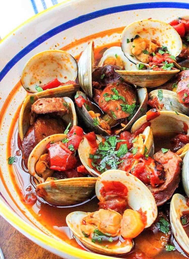 Plato de almejas en salsa con pimientos y perejil, una propuesta gastronómica para completar qué ver en Sintra en un día.