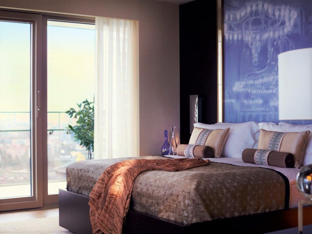 Habitación de hotel moderna con balcón y vistas, una opción cómoda para decidir donde alojarse en Estambul.