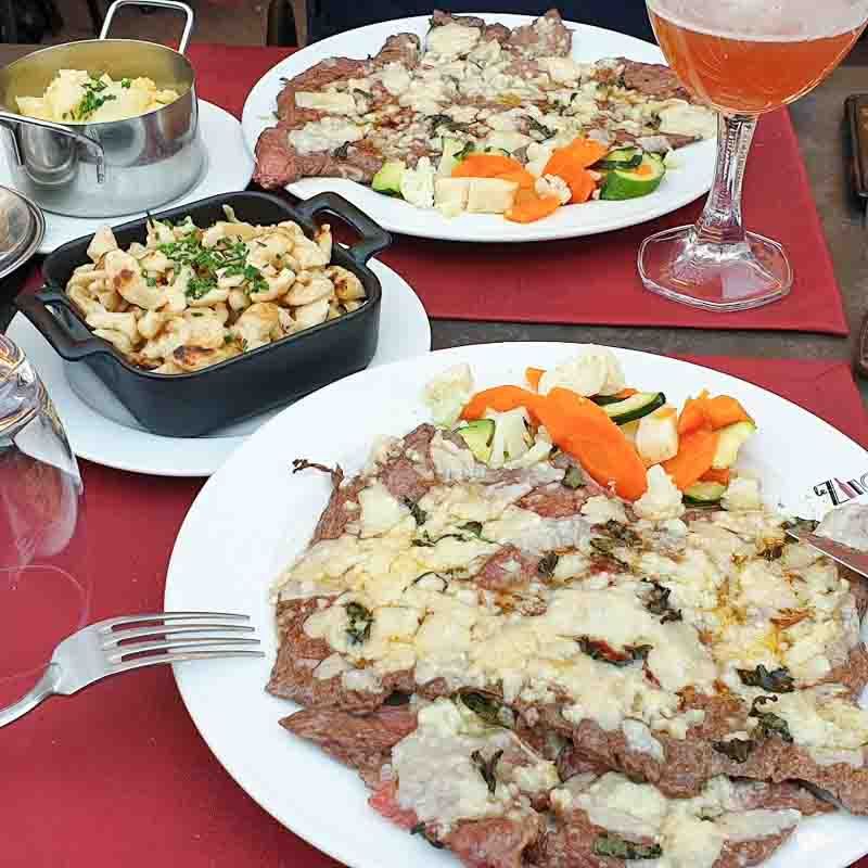 Tabla de quesos, embutidos y vino alsaciano en un restaurante, una opción perfecta para tapear si buscas donde comer en Colmar.