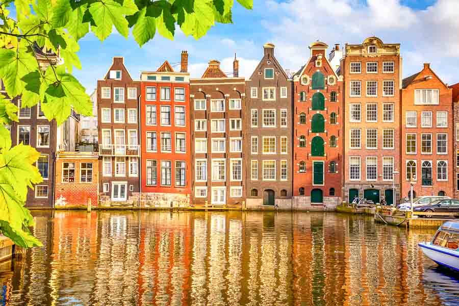 Casas tradicionales reflejadas en los canales, una de las postales imprescindibles de Ámsterdam en un día.