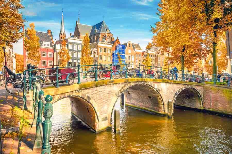 Puente con bicicletas sobre un canal de Ámsterdam, una imagen clásica para disfrutar Ámsterdam en un día.