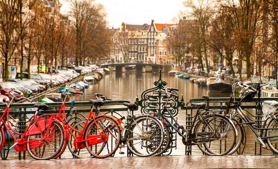 Bicicletas aparcadas junto a un canal, una estampa típica para recorrer Amsterdam en un dia.