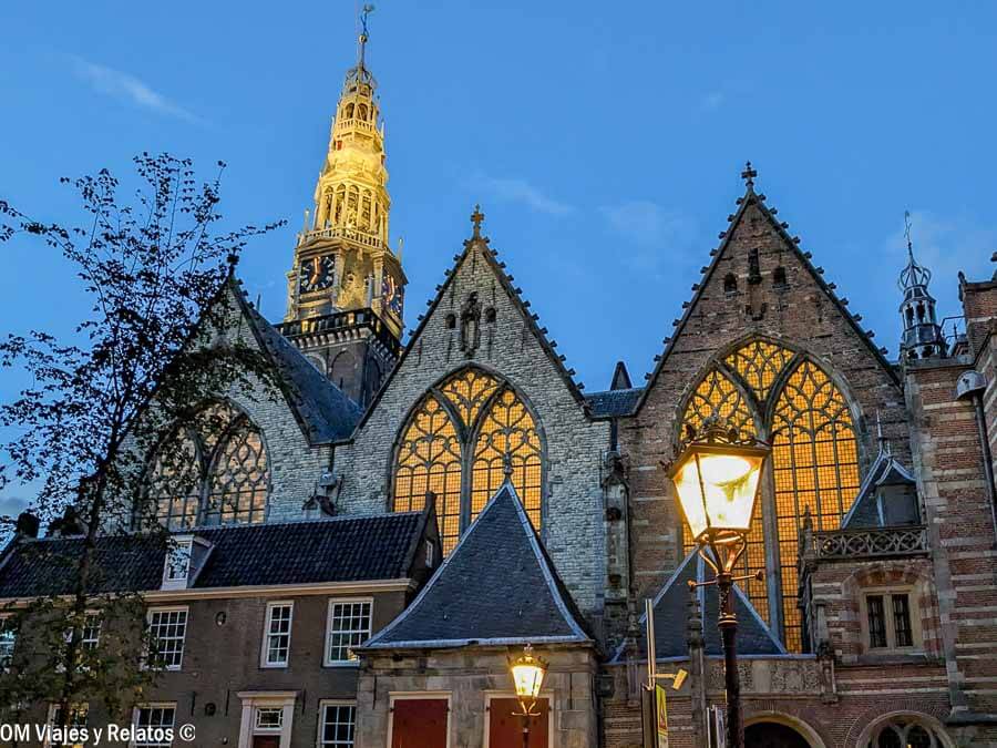 Iglesia gótica iluminada al atardecer en el centro de la ciudad, una parada con encanto sobre Amsterdam en un día.