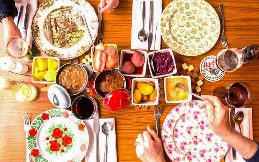 Mesa con platos tradicionales en un restaurante local, una experiencia gastronómica para completar Ámsterdam en un día.