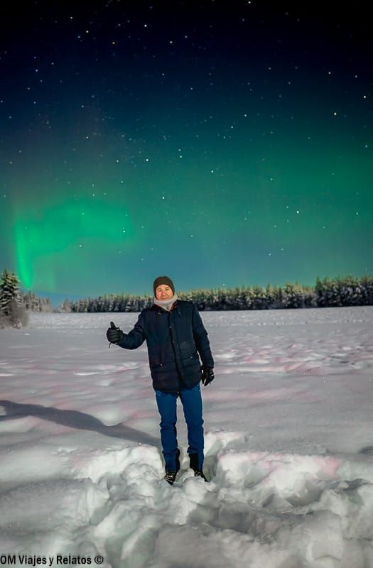 Foto de JC en la nieve con la aurora boreal de fondo y cielo estrellado, ideal para ver auroras boreales en Rovaniemi.