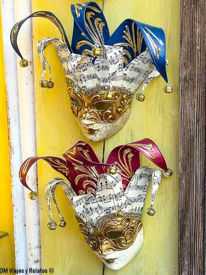 Máscaras venecianas tipo arlequín con detalles dorados y música, un recuerdo típico que comprar y que hacer en Venecia en Carnaval.