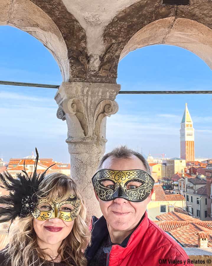 Foto mía y de JC con máscaras de Carnaval disfrutando de las vistas de Venecia desde un mirador, un plan genial que hacer en Venecia en Carnaval.