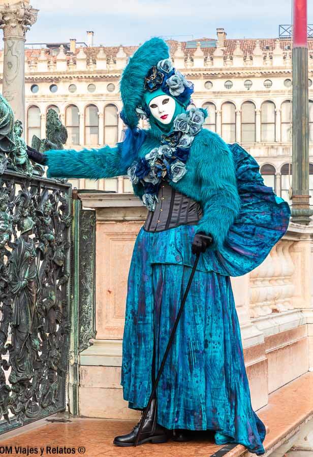 Disfraz azul con máscara veneciana posando en la calle, una de las mejores fotos que hacer en Venecia en Carnaval.