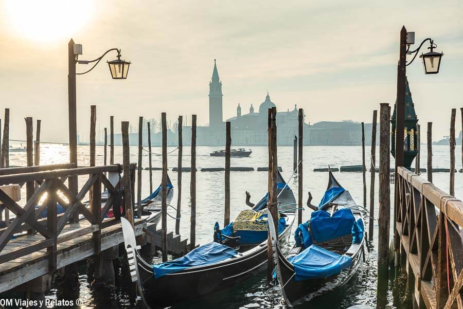 Góndolas amarradas al atardecer con vista a San Giorgio Maggiore, un plan romántico que hacer en Venecia en Carnaval.