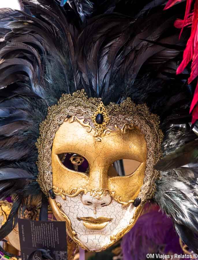 Máscara veneciana dorada con plumas negras, un accesorio elegante que ver y que hacer en Venecia en Carnaval.