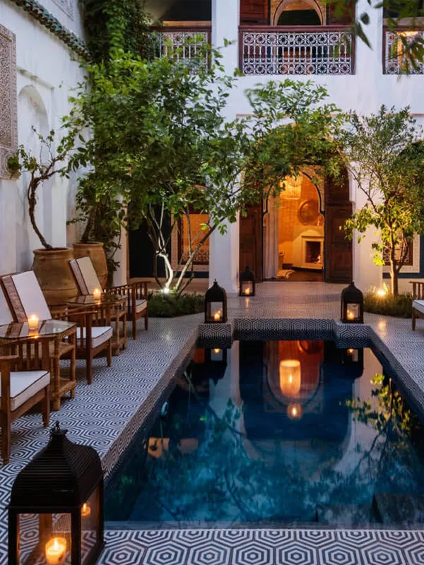 Patio con piscina iluminada del Riad Les Yeux Bleus en Marrakech, una estancia con encanto entre los mejores riads donde alojarse en Marrakech.