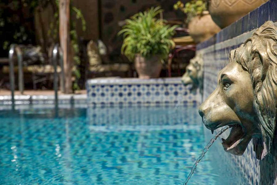 Piscina del riad Palais Sebban en Marrakech con fuente decorativa, una estancia de lujo entre los mejores riads donde alojarse en Marrakech.