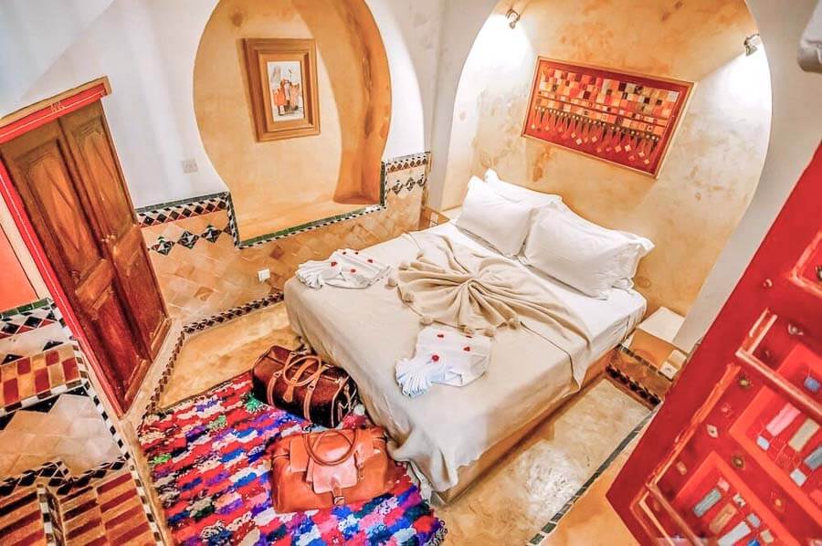Habitación con arcos y decoración tradicional en Riad Chorfa, una opción con encanto entre los mejores riads donde alojarse en Marrakech.