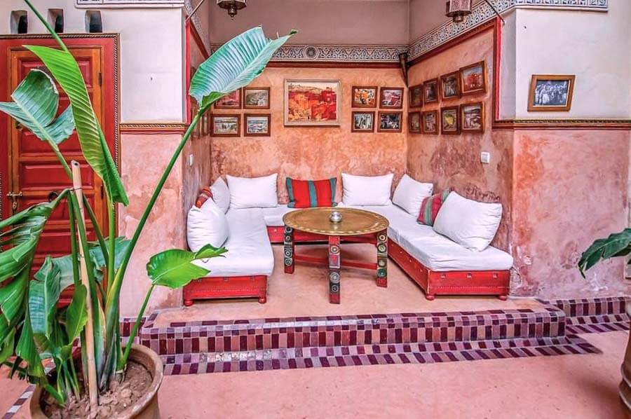 Rincón tradicional del Riad Chorfa en Marrakech con sofás y mesa baja, un alojamiento con encanto entre los mejores riads donde alojarse en Marrakech.