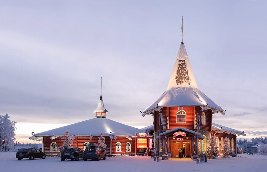 Pueblo de Santa Claus en Rovaniemi cubierto de nieve al atardecer, una de las primeras paradas al buscar como ir del aeropuerto de Rovaniemi al centro.
