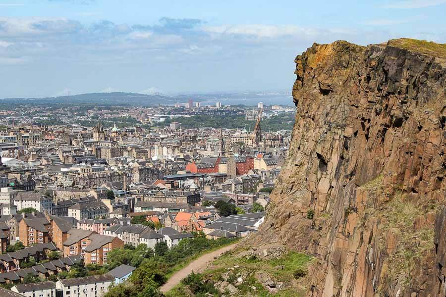 Vistas de Edimburgo desde Arthur’s Seat con acantilados en primer plano, un paisaje natural imprescindible que ver en Edimburgo en 4 días.