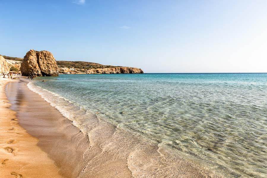 Vista de la playa de Firiplaka con su arena dorada y aguas turquesas, considerada una de las mejores playas de Milos.