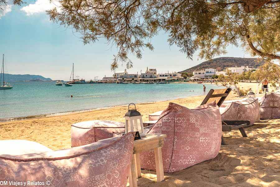 Zona chill out con pufs en la arena frente al mar en Pollonia Beach, una de las mejores playas de Milos para disfrutar con estilo.