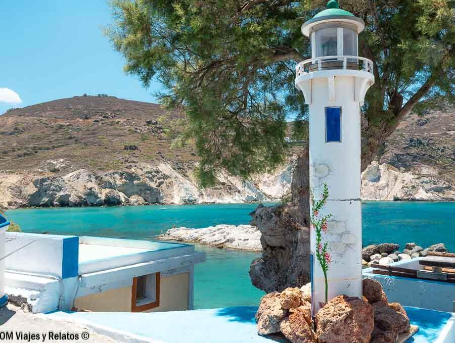 Faro blanco junto a aguas turquesas en Milos, Grecia, un paisaje icónico de las mejores playas de Milos.